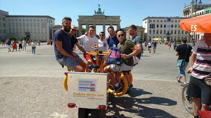 Happy customers from Australia on a guided sightseeing tour with one of our FunBikes/Teambikes/ConferenceBikes in front of the Brandenburg Gate